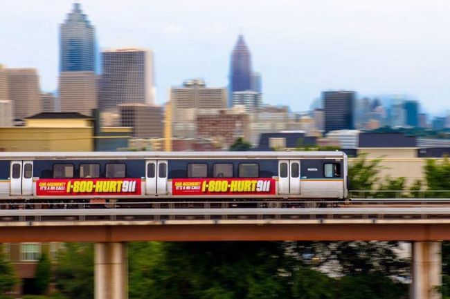 Static billboards on trains, advertising the vanity phone number 1-800-HURT-911®