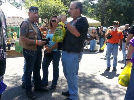 Bikers holding yellow bags advertising motorcycle lawyers and motorcycle awareness. The bags are full of giveaways