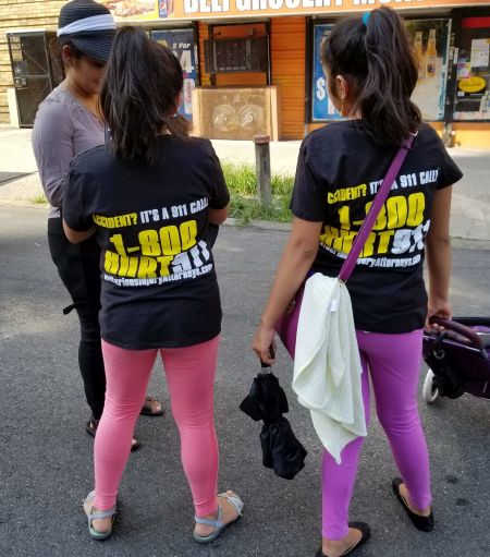 Two girls at the street fair wearing 1-800-HURT-911® T-shirts
