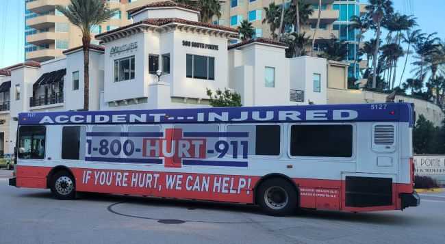billboard with 1-800-HURT-911 lawyer advertising on a bus